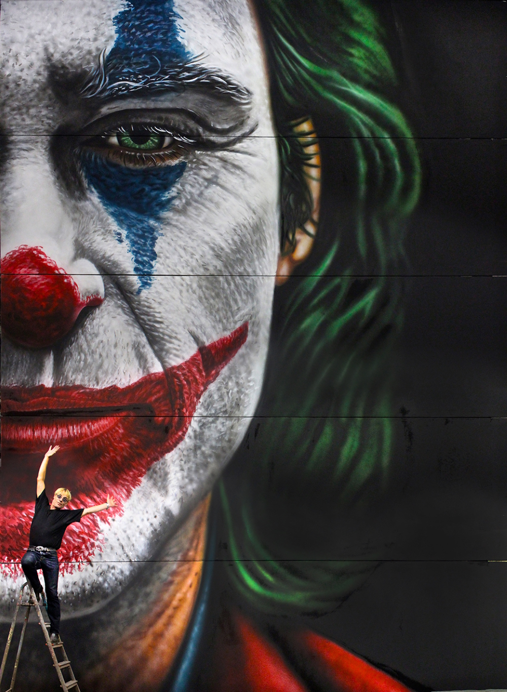 'Joker' (billboard size: 900x674cm @ Kino International respectively 600x900cm @ Delphi Filmpalast): huge supervillain's famous face, small painter on the ladder in front of his billboard for the 2019 psychological thriller film that stars Joaquin Phoenix. 