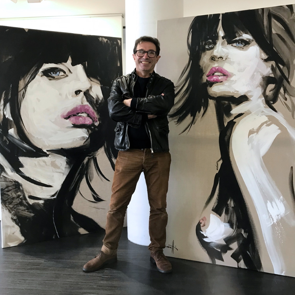 Michel Canetti in front of two of his paintings