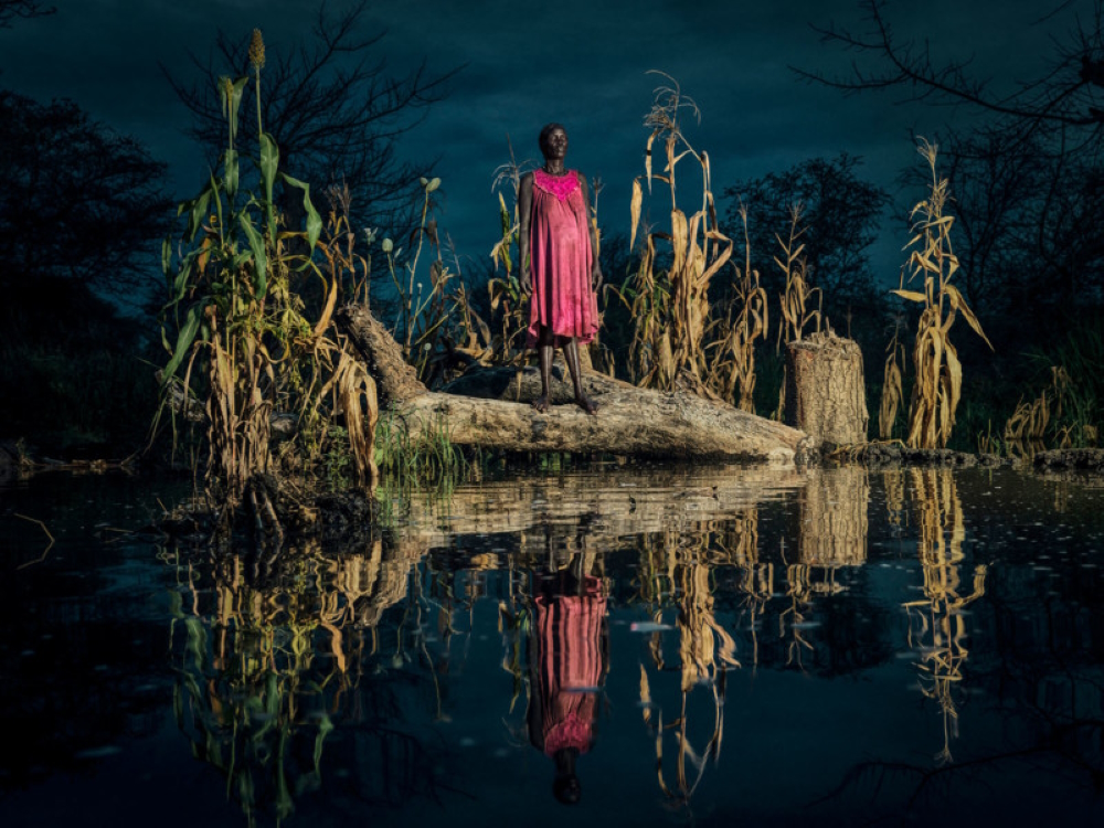 Nyadiang Gak, 50, beside her flooded crops after trying for the second time to harvest food. (From 