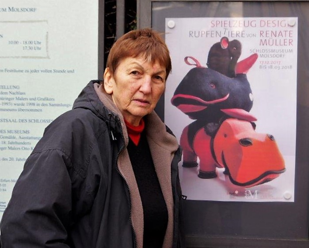 Renate Mueller in front of a poster for one of her exhibitions