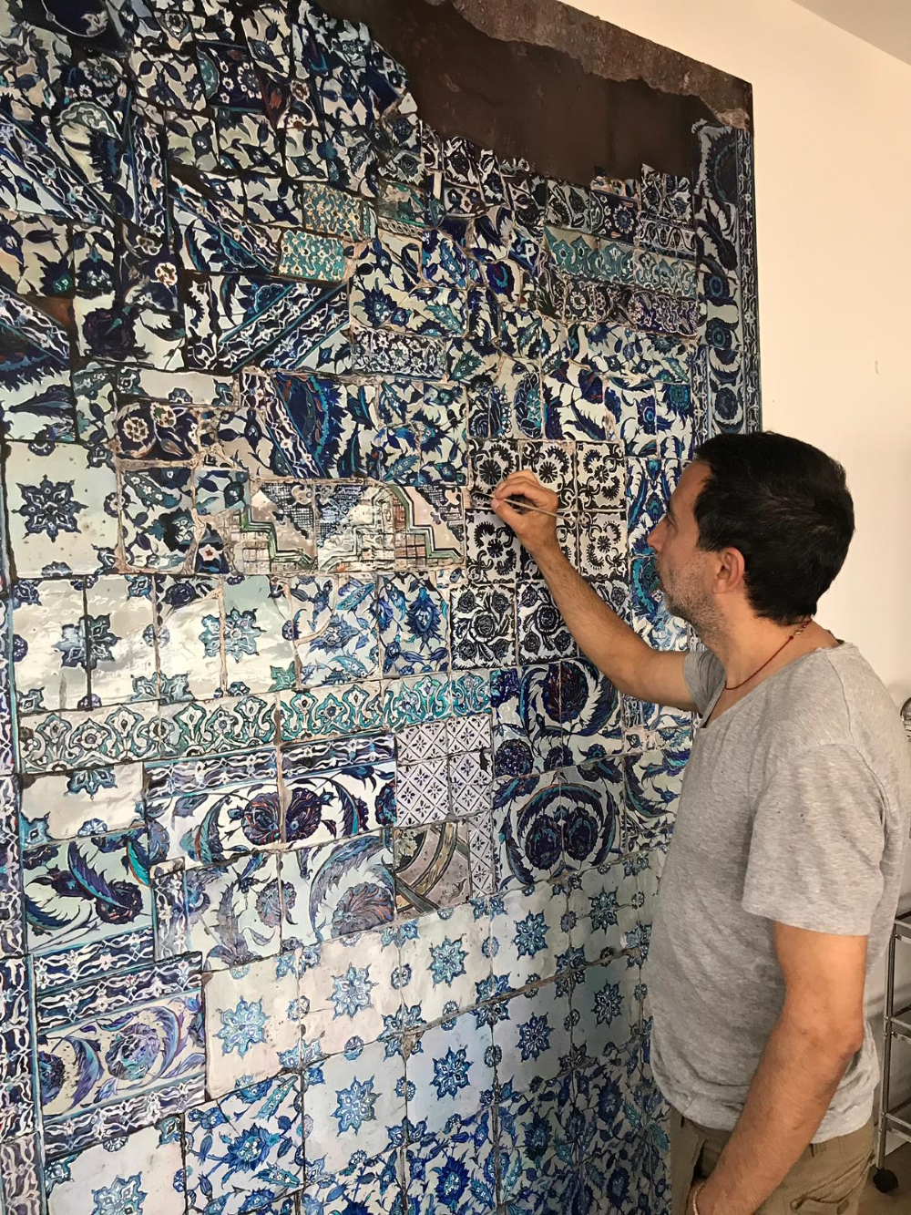 Every little thing counts for a hyper-realist painter like Taner Ceylan. He's shown here working on  'Duvar / The Wall'  (2018, oil on canvas, 240 x 160 cm).